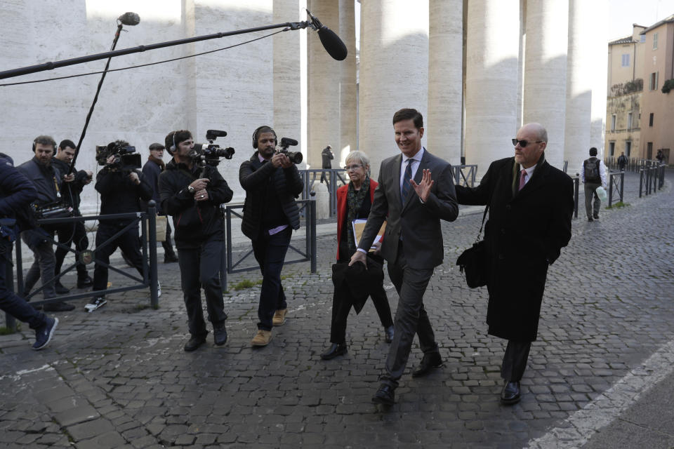 Juan Carlos Cruz, second from right, waves to journalists as walks to meet with organizers of the summit on preventing sexual abuse at the Vatican, Wednesday, Feb. 20, 2019. A dozen survivors of clergy sexual abuse met with organizers of Pope Francis' landmark summit on preventing abuse and protecting children. Chilean survivor Juan Carlos Cruz, who was asked by the Vatican to invite survivors to the meeting, told reporters Wednesday that Francis would not be attending, as had been rumored. (AP Photo/Gregorio Borgia)