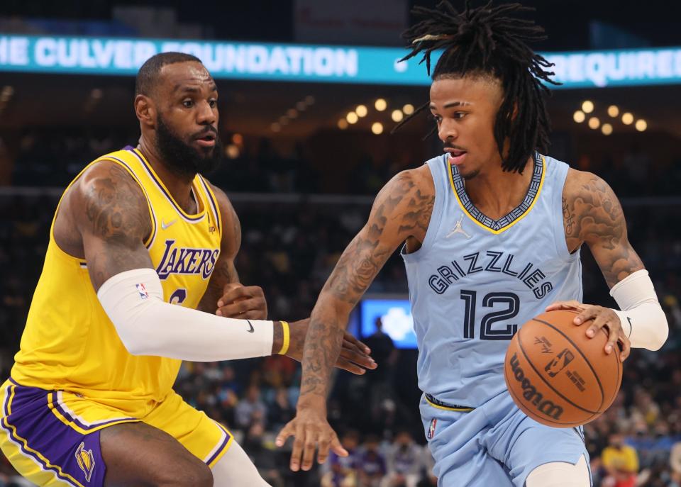 Memphis Grizzlies guard Ja Morant looks to drive past the defense of Los Angeles Lakers forward LeBron James at FedExForum on Wednesday, Dec. 29, 2021.