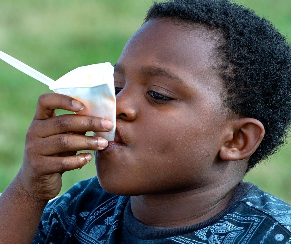 Psyere Bradley, 9, of Bristol Borough, sips the remainder of his mango water ice, during the National Night Out in Bristol Borough, which was held at the Snyder-Girotti Elementary School, on Tuesday, Aug. 2, 2022.