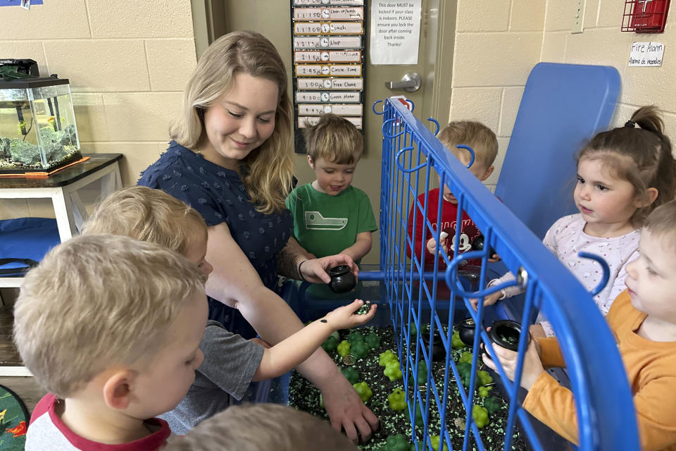 Rylee Monn plays with her class at a child care center in Lexington, Ky., Wednesday, March 13, 2024. Monn, who has two children at the center where she works, is taking advantage of a state program that offers free or reduced cost child care to child care workers. Monn says the program saves her family hundreds of dollars a week. (AP Photo/Dylan Lovan)