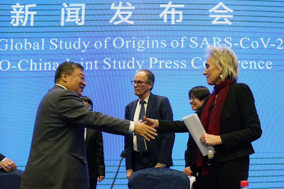 FILE - Marion Koopmans, right, and Peter Ben Embarek, center, of the World Health Organization team say farewell to their Chinese counterpart Liang Wannian, left, after a WHO-China Joint Study Press Conference at the end of the WHO mission in Wuhan, China, on Feb. 9, 2021. The hunt for COVID-19 origins has gone dark in China. An AP investigation drawing on thousands of pages of undisclosed emails and documents and dozens of interviews found feuding officials and fear of blame ended meaningful Chinese and international efforts to trace the virus almost as soon as they began, despite years of public statements to the contrary. (AP Photo/Ng Han Guan, File)