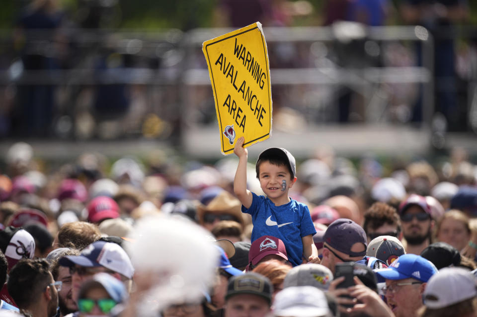 A young fan holds up a sign during a rally for the Colorado Avalanche outside the City/County Building for the NHL hockey champions, after a parade Thursday, June 30, 2022, in Denver. (AP Photo/David Zalubowski)