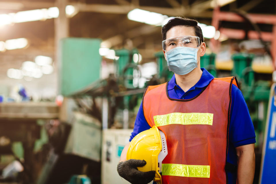 Asian Worker wear disposable face mask for protection coronavirus spreading and smoke dust air pollution filter in factory. Credit: Getty.