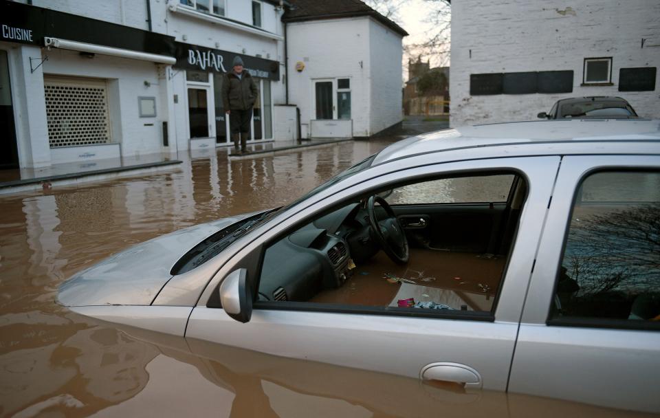 Flood water surrounds abandoned cars left in a flooded street in Tenbury Wells, after the River Teme burst its banks in western England, on February 16, 2020, after Storm Dennis caused flooding across large swathes of Britain. - A man died after falling into a river on Sunday as Storm Dennis swept across Britain with the army drafted in to help deal with heavy flooding and high winds. (Photo by Oli SCARFF / AFP) (Photo by OLI SCARFF/AFP via Getty Images)