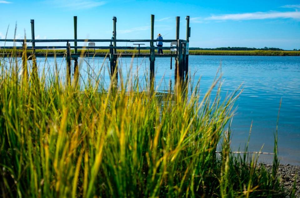 A lady fishes from the docks at low tide at Bowen’s Island Restaurant. Oct. 4, 2021.