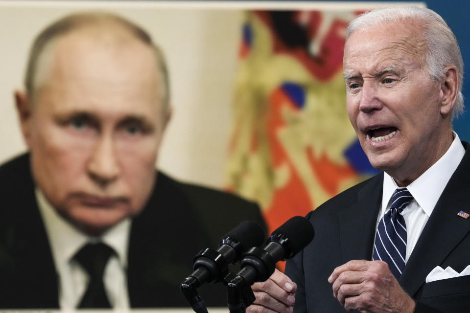 An image of Russian President Vladimir Putin is displayed as President Biden speaks at the White House, 