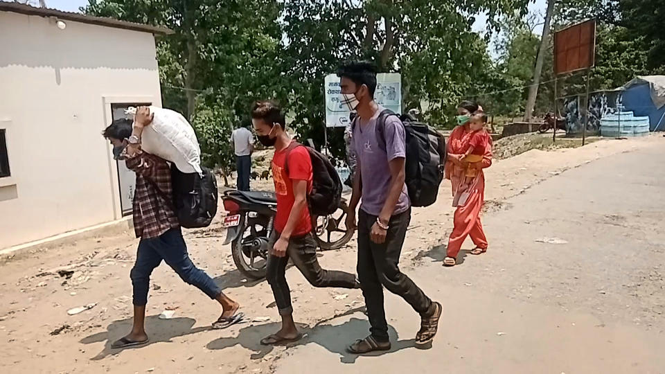 Nepalese migrant workers cross back into Nepal from India at the Kailali border crossing, where thousands have re-entered the country. (Mercy Corps)