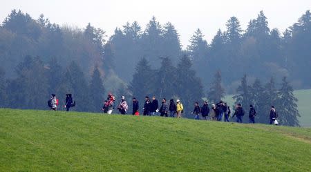 File photo of migrants crossing a field as they walk from the Austrian village of Kollerschlag towards the Austrian-German border in Wegscheid near Passau, Austria, October 20, 2015. REUTERS/Michael Dalder/Files