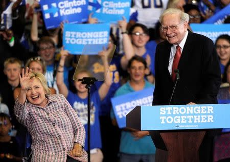 U.S. Democratic presidential candidate Hillary Clinton waves to supporters as she is introduced by Warren Buffett during a campaign rally at the Omaha North High Magnet School in Omaha, Nebraska August 1, 2016. REUTERS/Dave Kaup