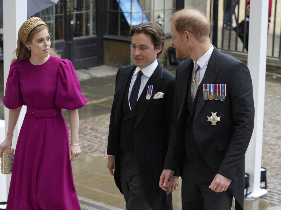 El príncipe Enrique, la princesa Beatriz y Edoardo Mapelli Mozzi llegan a la Abadía de Westminster, previo a la ceremonia de coronación del rey Carlos III y la reina consorte Camila, en Londres, el sábado 6 de mayo de 2023. (Dan Charity/Pool Photo vía AP)