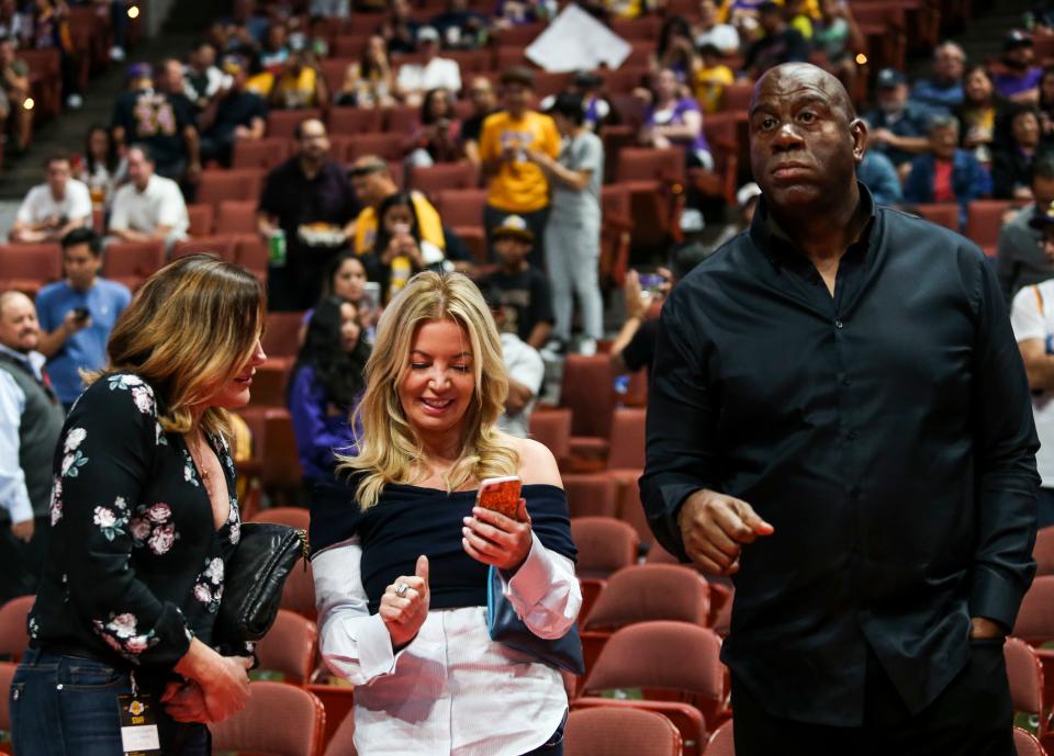 Jeanie Buss, center, and Magic Johnson attend an NBA preseason basketball game between Los Angeles Lakers and Minnesota Timberwolves in Anaheim, Calif., Saturday, Sept. 30, 2017. (AP Photo/Ringo H.W. Chiu)