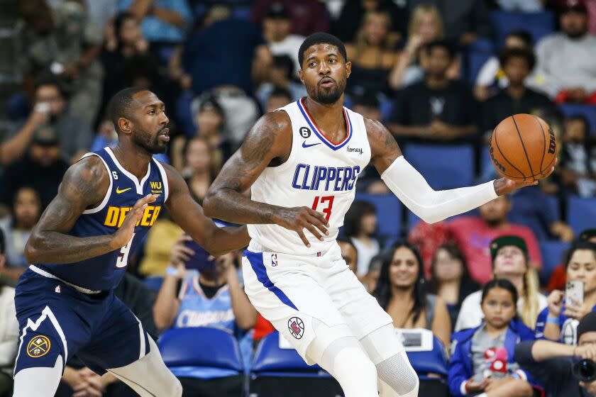 Los Angeles Clippers forward Paul George, right, is defended by Denver Nuggets guard Davon Reed