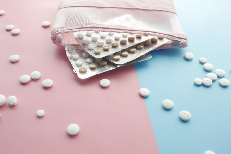 birth control pills on wooden background, close up