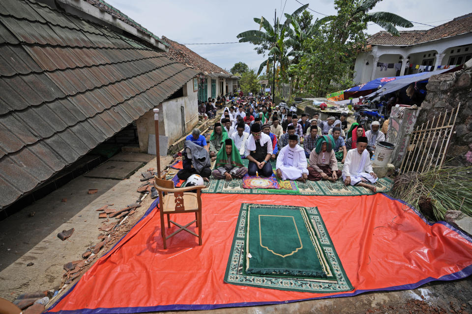 Muslim men perform a Friday prayer outside a mosque badly damaged in Monday's earthquake in Gasol village, Cianjur, West Java, Indonesia, Friday, Nov. 25, 2022. The magnitude 5.6 quake on Monday killed hundreds of people, many of them children and injured thousands. (AP Photo/Achmad Ibrahim)