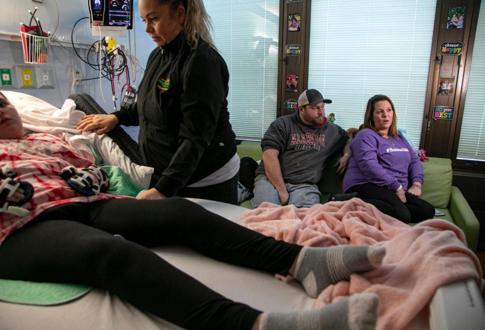 Physical therapist assistant Starr Sutton works with Savanah DeHart, 15, during an afternoon rehabilitation segment at the Mary Free Bed Rehabilitation Hospital in Grand Rapids Thursday, Jan. 23, 2020 to treat the debilitating effects of the Triple E (Eastern Equine Encephalitis) virus. DeHart was likely bitten by a an infected mosquito last summer and suffered stroke-like symptoms. Savanah's stepfather Rodney Dooley and mother Kerri Dooley are pictured at right.