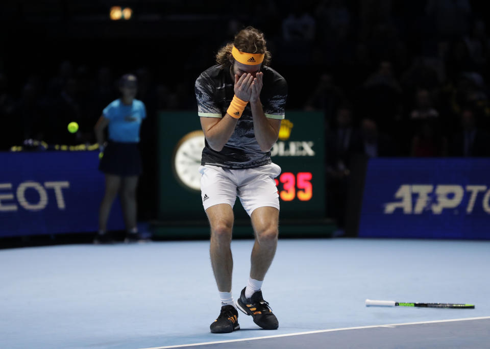 Stefanos Tsitsipas of Greece drops his racquet as he wins and defeats Austria's Dominic Thiem in their ATP World Finals singles final tennis match at the O2 arena in London, Sunday, Nov. 17, 2019. (AP Photo/Kirsty Wigglesworth)