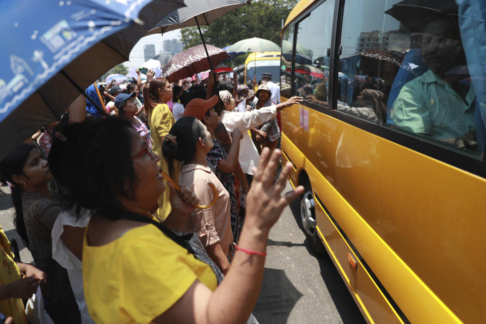 Released prisoners sit in a bus and are welcomed by family members and colleagues after they were released from Insein Prison Wednesday, April 17, 2024, in Yangon, Myanmar. On Wednesday Myanmar's military government granted amnesty for over 3,000 prisoners to mark this week’s traditional New Year holiday. (AP Photo/Thein Zaw)