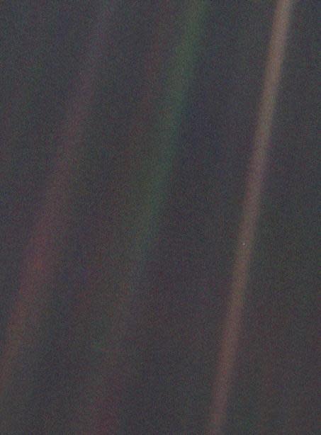 Portion of the famous solar system portrait taken on Feb. 14, 1990 by NASA's Voyager 1 probe. Earth is visible as a pale blue dot at right, in the yellow bar.