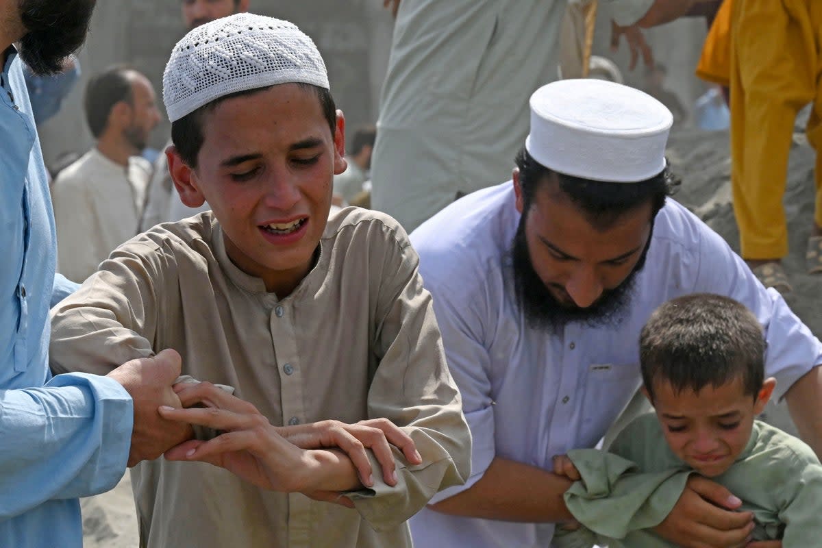 Boys weep the death of their family member, a day after bomb blast in Bajaur district (AFP via Getty Images)