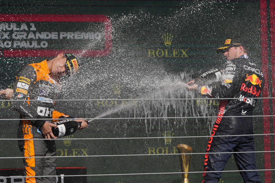 Winner Red Bull driver Max Verstappen of the Netherlands, right, sprays champagne on the podium with second place McLaren driver Lando Norris of Britain at the end of the Brazilian Formula One Grand Prix at the Interlagos race track in Sao Paulo, Brazil, Sunday, Nov. 5, 2023. (AP Photo/Andre Penner)