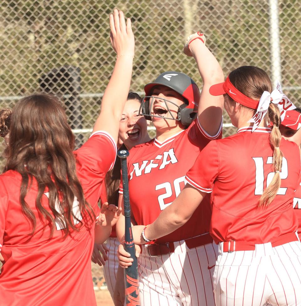 NFA's Ameila Driscoll, center, is congratulated by teammates after hitting a three-run homer during the Wildcats' 10-3 win over East Lyme in Niantic.