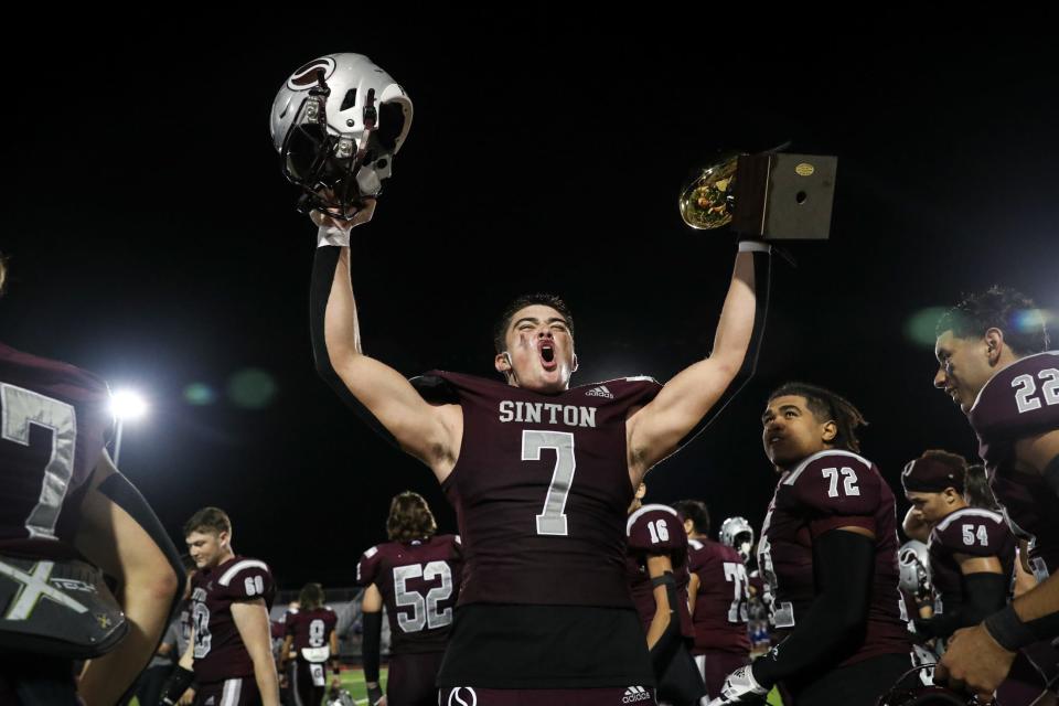 Sinton’s Colby Hasseltine hoists the district trophy after in the air after defeating Ingleside 42- 14 at Pirate Stadium on Friday, Nov. 3, 2023, in Sinton, Texas.