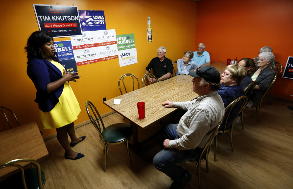 In this Wednesday, Oct. 3, 2018 photo, Iowa Democratic candidate for secretary of state Deidre DeJear, left, talks to local residents during a campaign stop in Osage, Iowa. DeJear is an example, perhaps the best, of Democrats around the country fighting for this lesser-known statewide office in 2018 over what has been a steady tightening of voting rules in states under Republican leadership. (AP Photo/Charlie Neibergall)