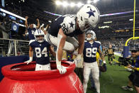 Dallas Cowboys' Dalton Schultz (86) jumps out of a Salvation Army kettle while celebrating Peyton Hendershot's (89) touchdown along with Sean McKeon (84) during the second half of an NFL football game against the New York Giants Thursday, Nov. 24, 2022, in Arlington, Texas. (AP Photo/Tony Gutierrez)