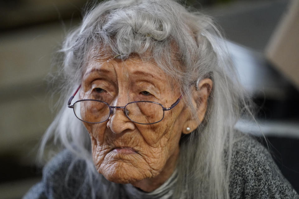 Tanacross resident 99-year-old Isabel John is shown sitting at her dining room table Thursday, Sept. 23, 2021, in Tanacross, Alaska. Her husband, 82-year-old Arthur John, was hospitalized for nearly 30 days and lost more than 40 pounds after contracting COVID-19 last winter. Most elders encourage their fellow Tanacross residents to get vaccinated, something especially important now as the statewide surge in cases is causing a strain on healthcare statewide. (AP Photo/Rick Bowmer)