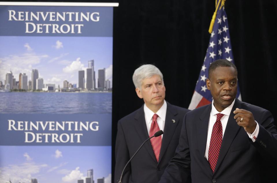 FILE - In this July 19, 2013, file photo, state-appointed emergency manager Kevyn Orr, right, and Michigan Gov. Rick Snyder, address reporters during a news conference in Detroit after Orr asked a federal judge for bankruptcy protection. Orr chose bankruptcy over diverting money from police, fire and other services to make debt payments. The move conserves cash so the city can operate, but it will hurt Detroit's image for years. It will also leave creditors with much less than they are owed and places in jeopardy the pension benefits of thousands of city retirees. (AP Photo/Carlos Osorio, File)