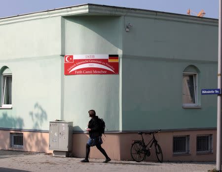 A woman walks past the sign of a mosque in Dresden, Germany on September 27, 2016, one day after an improvised bomb destroyed the entrance. REUTERS/Matthias Schumann