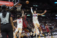Miami Heat guard Terry Rozier, center, goes to the basket as Washington Wizards forward Corey Kispert (24) and forward Kyle Kuzma (33) defend during the second half of an NBA basketball game, Sunday, March 10, 2024, in Miami. (AP Photo/Lynne Sladky)