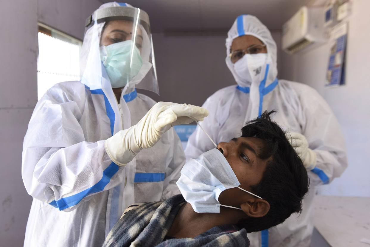 A health worker collects a nasal swab sample from a Central Public Works Department worker to test for the Covid-19 coronavirus, on the outskirts of Amritsar on February 24, 2021. (Photo by NARINDER NANU / AFP) (Photo by NARINDER NANU/AFP via Getty Images)