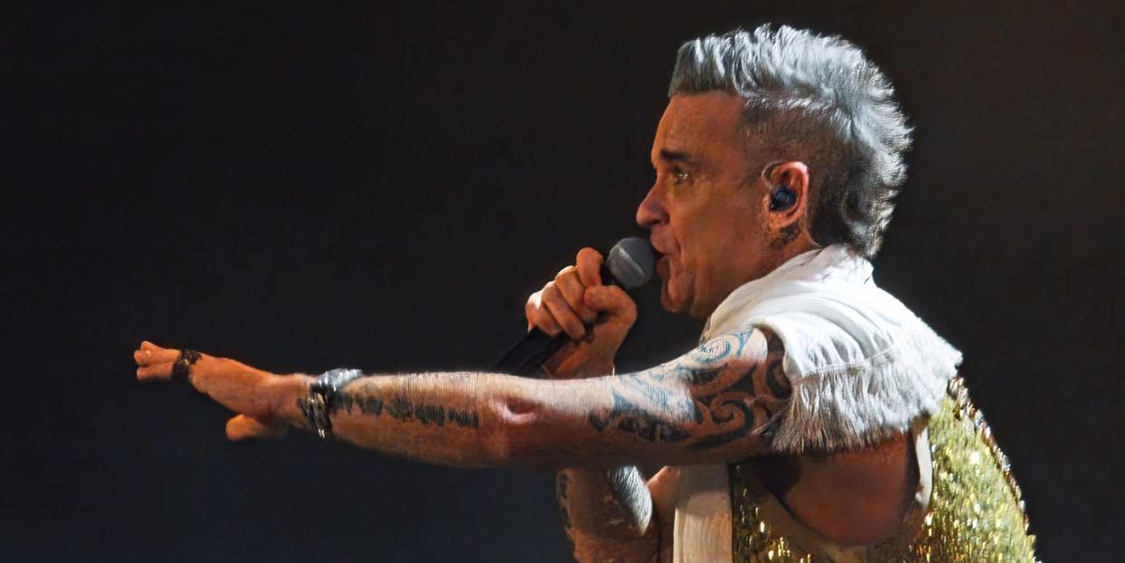 robbie williams singing into a microphone