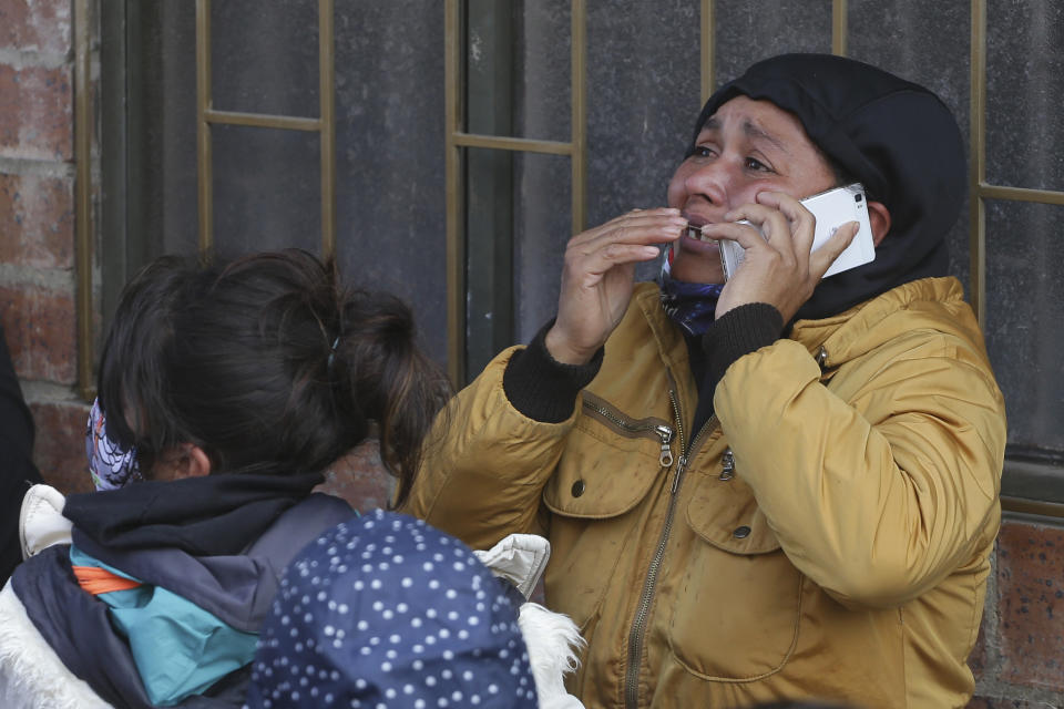 FILE - In this March 22, 2020 file photo, the relative of an inmate cries as she speaks on the phone outside La Modelo jail in Bogota, Colombia. Violence broke out in the prison out of inmates' fears that authorities are not doing enough to prevent coronavirus inside overcrowded prisons. (AP Photo/Ivan Valencia, File)