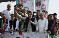 Pakistan's former Prime Minister Imran Khan, center, addresses to his supporters at a rally in Lahore, Pakistan, Saturday, Oct. 29 2022. Khan along with thousands of his supporters in a large convoy of buses and cars Friday began his much-awaited march on the capital Islamabad from the eastern city of Lahore to demand the holding of snap elections, a sign of deepening political turmoil. (AP Photo/K.M. Chaudary)