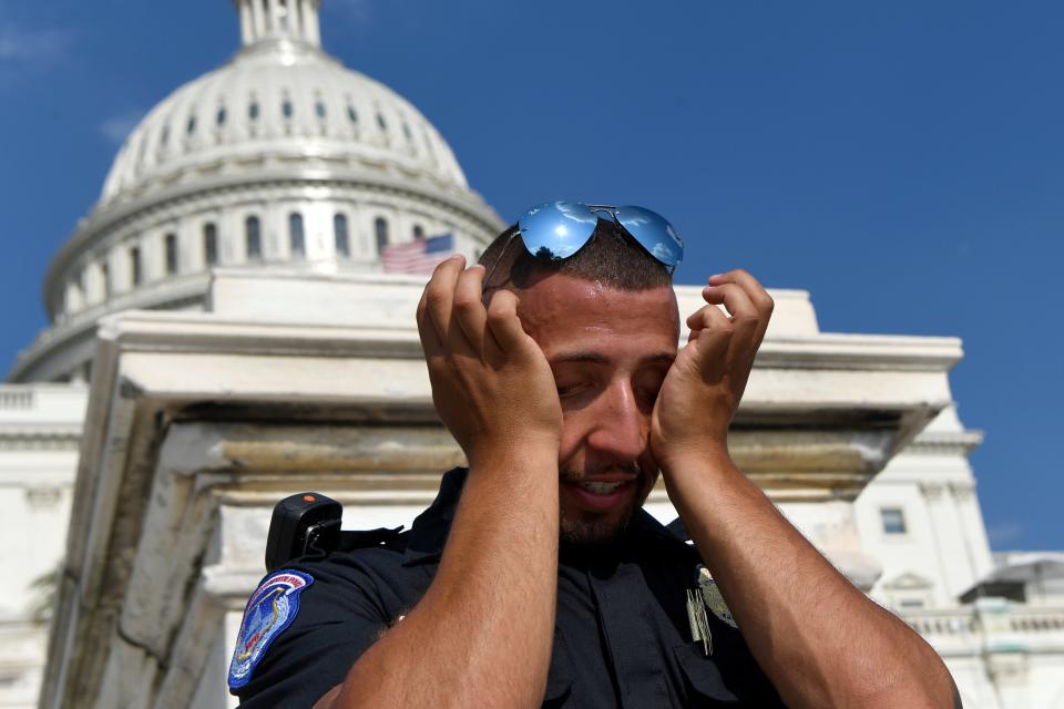 A U.S. Capitol Police officer wipes sweat from his eyes as he stands his post Saturday, July 20, 2019, on the West side of Capitol Hill in Washington.