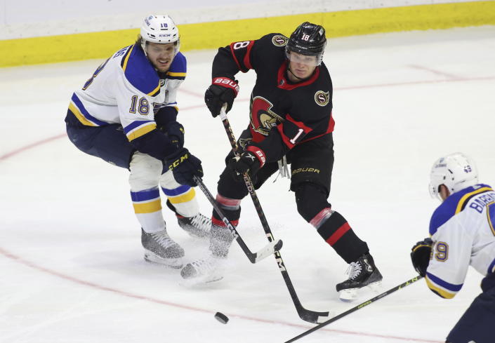 Ottawa Senators Tim Stutzle (18) passes the puck while St. Louis Blues Robert Thomas (18) and Ivan Barbashev (49) defend during second-period NHL hockey game action in Ottawa, Ontario, Sunday, Feb. 19, 2023. (Patrick Doyle/The Canadian Press via AP)