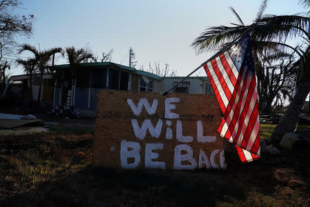 A "We Will Be Back" sign and U.S. flag are pictured following Hurricane Irma in Big Pine Key,. Florida, U.S., September 18, 2017. REUTERS/Carlo Allegri