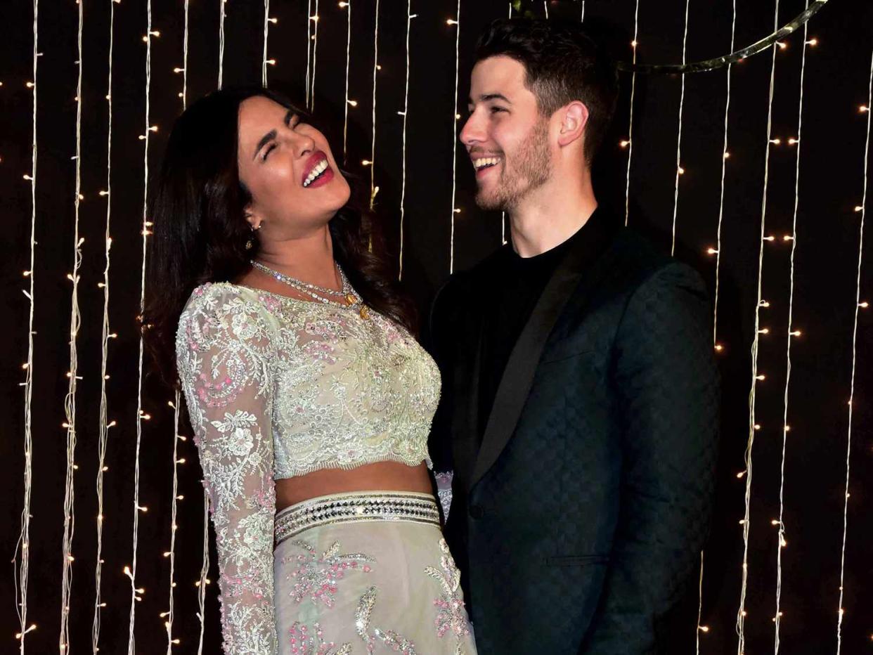 Priyanka Chopra (L) and musician Nick Jonas (R) pose for photographs at their wedding reception at hotel Taj Lands End in Mumbai.The newly-married couple, Priyanka Chopra and Nick Jonas held a reception party for their Bollywood folks at hotel Taj Lands End in Mumbai