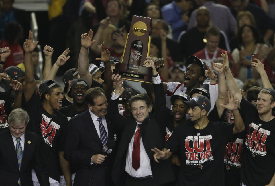 FILE - Louisville players and head coach Rick Pitino celebrate after defeating Michigan 82-76 in the final game at the NCAA Final Four tournament college basketball championship game Monday, April 8, 2013, in Atlanta. (AP Photo/Chris O'Meara, File)