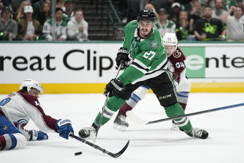 Dallas Stars left wing Mason Marchment (27) shoots as Colorado Avalanche's Samuel Girard, left, defends in the first period in Game 2 of an NHL hockey Stanley Cup second-round playoff series in Dallas, Thursday, May 9, 2024. (AP Photo/Tony Gutierrez)
