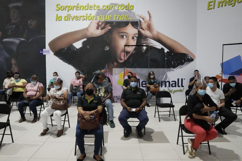 Residents sit in observation after getting shots of the AstraZeneca vaccine for COVID-19 at Mega Mall on the outskirts of Panama City, Wednesday, June 9, 2021. (AP Photo/Arnulfo Franco)