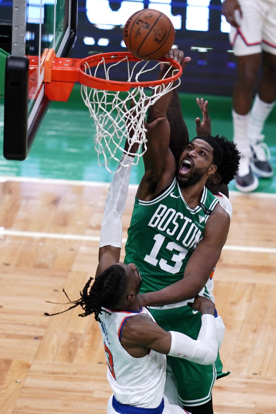 Boston Celtics center Tristan Thompson (13) dunks over New York Knicks center Nerlens Noel during the first half of an NBA basketball game Wednesday, April 7, 2021, in Boston. (AP Photo/Charles Krupa)