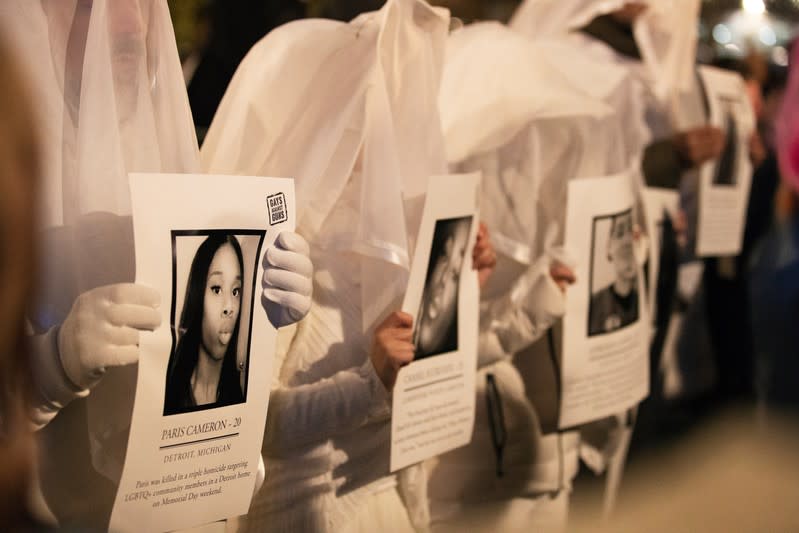 Activists dress in white and hold images of slain members of the LGBTQ community during a demonstration to commemorate Transgender Day of Remembrance in New York City