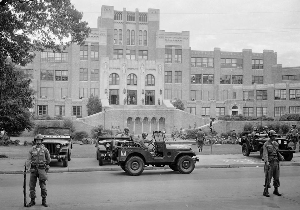 FILE - In this Sept. 26, 1957, file photo, members of the 101st Airborne Division take up positions outside Central High School in Little Rock, Ark. The troops were on duty to enforce integration at the school. (AP Photo/File)