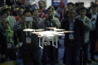 FILE - In this Jan. 7, 2016 file photo, a drone hovers at the DJI booth during CES International in Las Vegas. In Utah, drones are hovering near avalanches to measure roaring snow. In North Carolina, they're combing the skies for the nests of endangered birds. In Kansas, meanwhile, they could soon be identifying sick cows through heat signatures. A survey released Monday, May 20, 2019 shows transportation agencies are using drones in nearly every U.S. state. (AP Photo/John Locher, File)