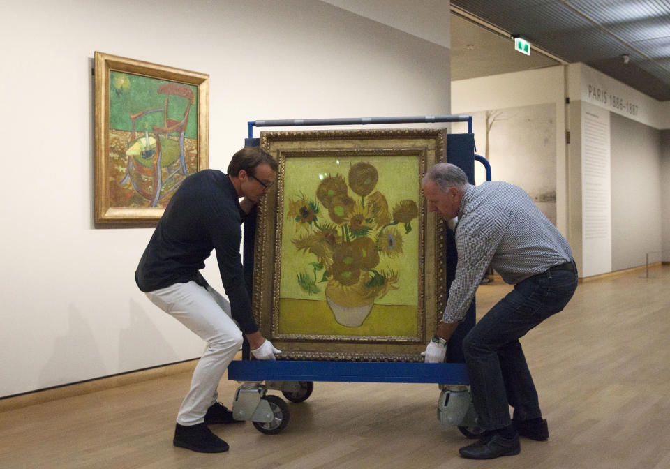 Curators are putting Vincent van Gogh's famous "Sunflowers" painting onto a felt-lined carrier trolley at the Van Gogh Museum in Amsterdam, Netherlands, Sunday, Sept. 23, 2012. While the museum closes for seven months for renovations, 75 works by the Dutch painter will be displayed instead across town at The Hermitage, an Amsterdam satellite of the Russian state museum. The tricky process of transporting the artworks under police escort began immediately after the last visitors left the museum Sunday evening and carried on through the night into Monday morning. The Van Gogh Museum reopens April 25, 2013. (AP Photo/Cris Toala Olivares)