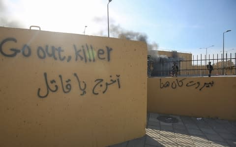 Graffiti left by protesters outside the US embassy - Credit: AHMAD AL-RUBAYE/AFP via Getty Image