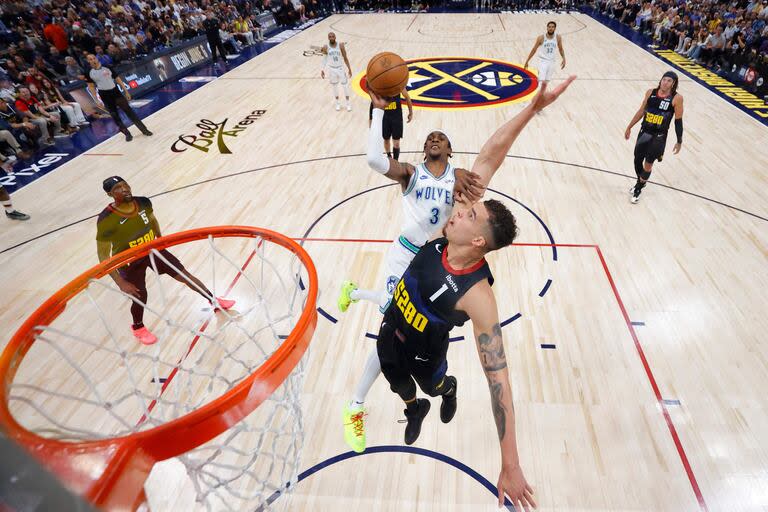 Jaden McDaniels, #3 de los Timberwolves, lanzando contra Michael Porter Jr., #1 de Denver Nuggets 